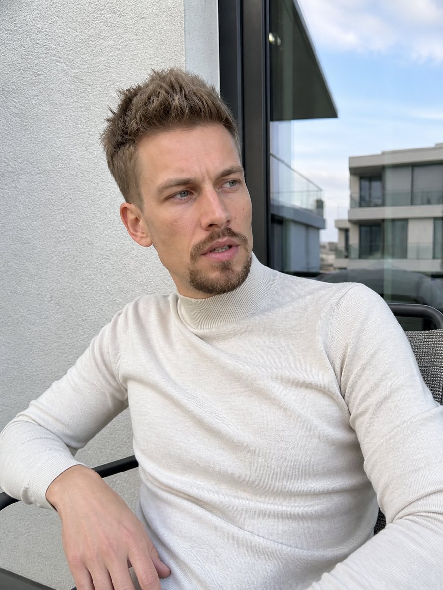 Lenny Helnwein im weißen Rollkragenpullover auf einer Terrasse in Wien